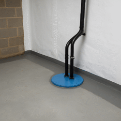 Basement waterproofing setup with blue sump pump and vapor barrier in Charlotte home
