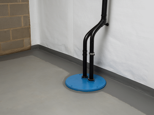 Basement waterproofing setup with blue sump pump and vapor barrier in Charlotte home