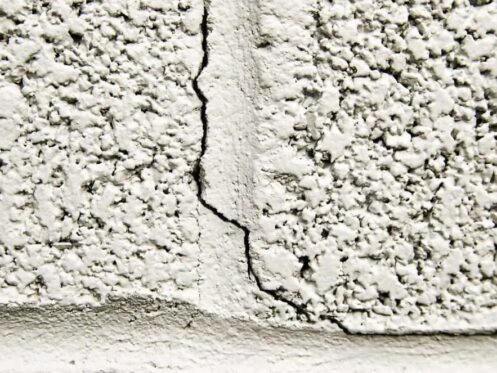Close-up of a crack in a home's exterior wall caused by winter weather effects on the foundation