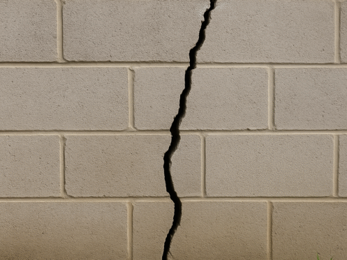 Large vertical crack in a cinder block foundation wall caused by settling
